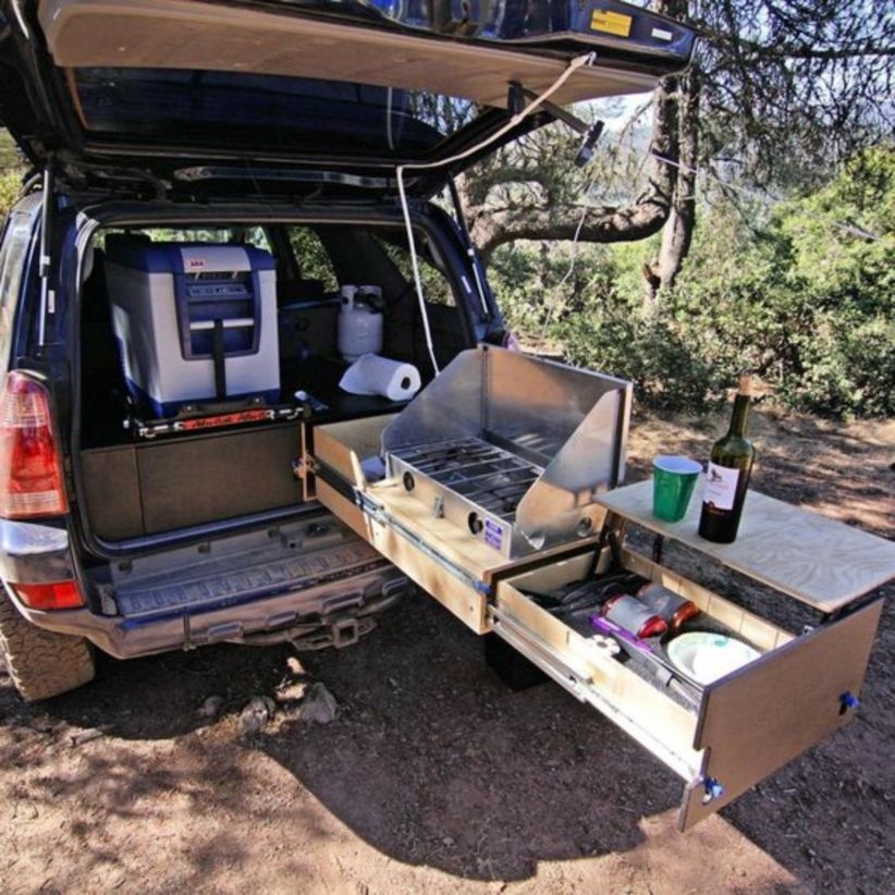 Suv camper has a bed frame with an abundance of storage underneath, a kitchen unit with a sink, many handy places for extra storage, a back-up camera, and much more