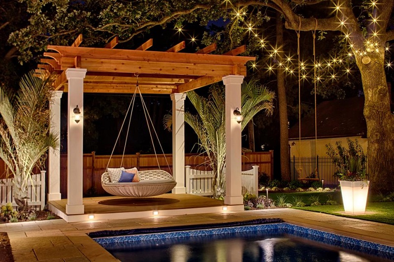 Pool area with swing bed at night